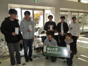 福山大学のMakersのブースの前で記念写真